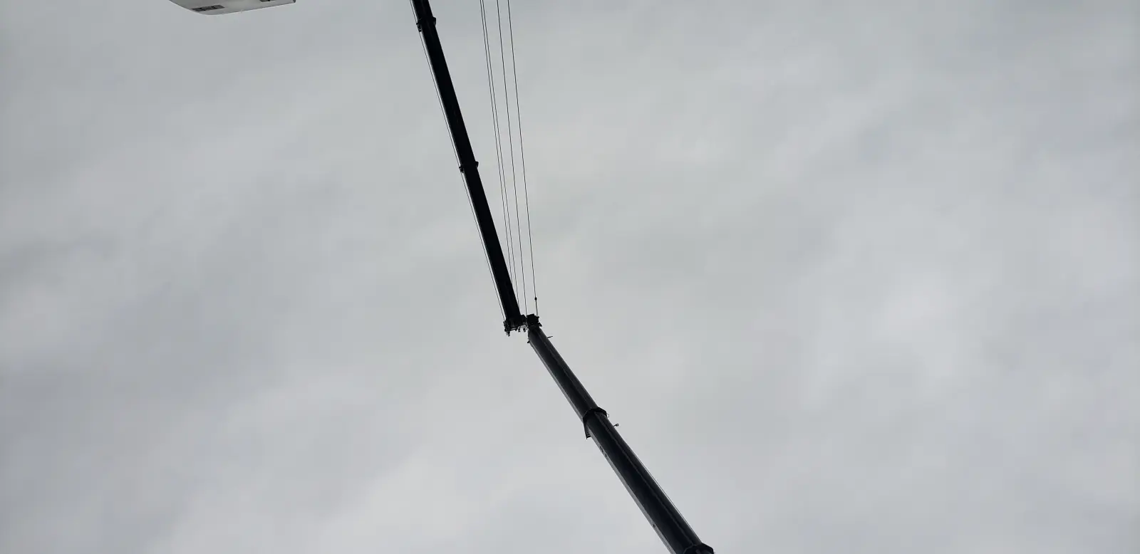 Large lattice boom crane against a dramatic sky