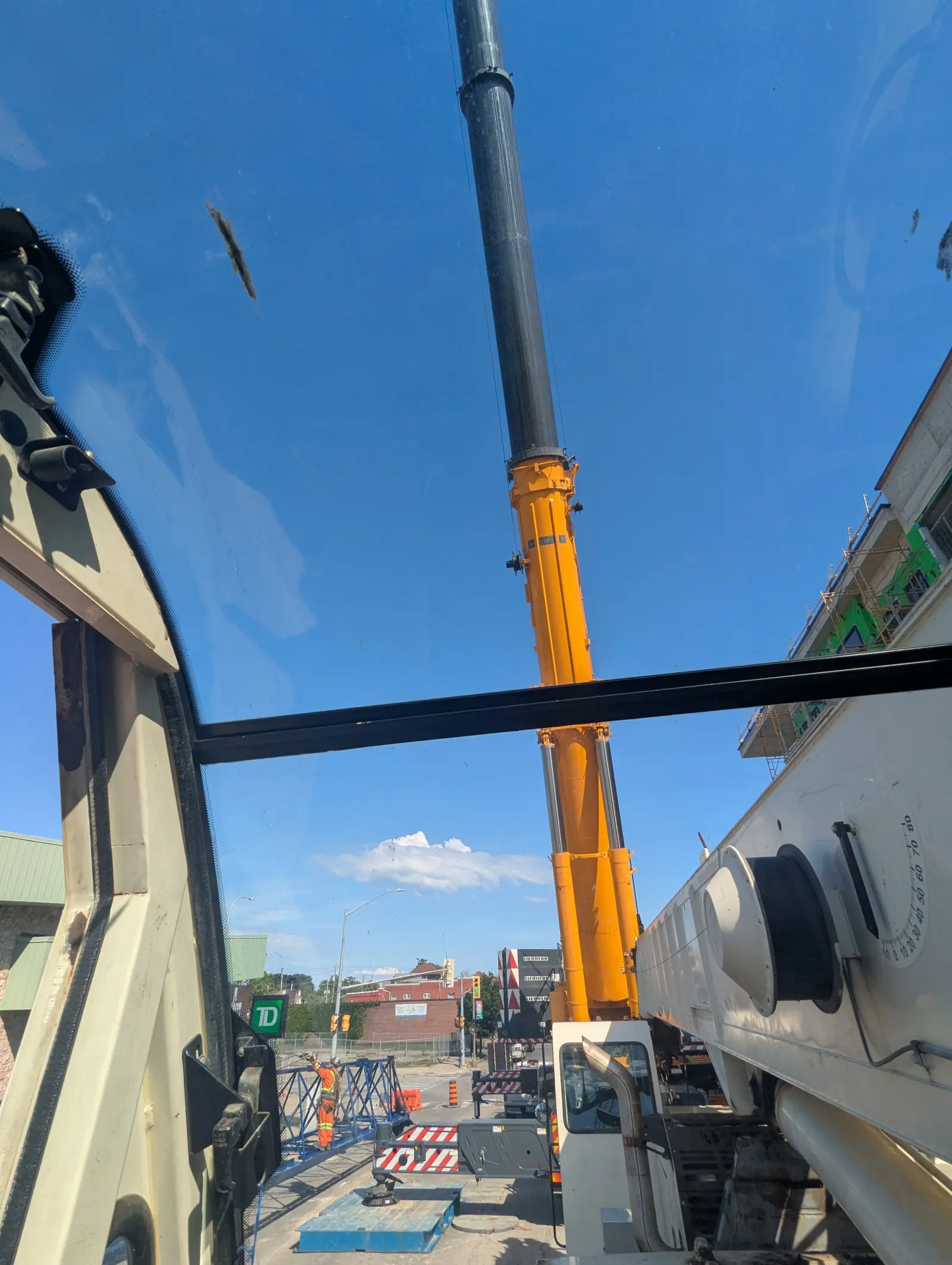 Crane boom against cloudy sky over an urban site